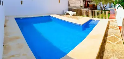 a large blue swimming pool in a backyard at Chalet Mari Carmen in Chiclana de la Frontera
