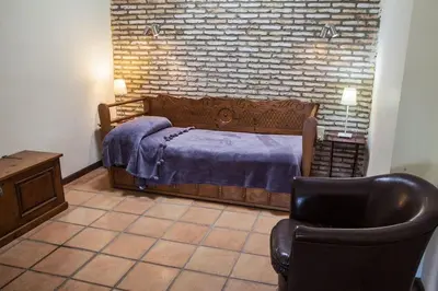 a bedroom with a bed and a chair at Apartamentos Turísticos Bahía Sur in San Fernando