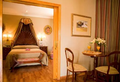 a bedroom with a bed and a table and chairs at La Cueva Park in Jerez de la Frontera
