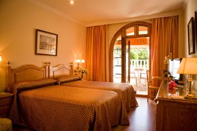 a hotel room with a bed and a balcony at La Cueva Park in Jerez de la Frontera