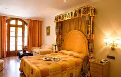 a bedroom with a large bed and a table at La Cueva Park in Jerez de la Frontera
