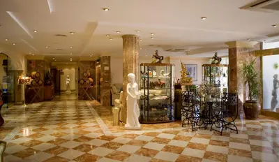 a lobby with a statue in the middle of a room at La Cueva Park in Jerez de la Frontera