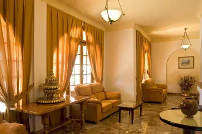a living room with a couch and a chair at La Cueva Park in Jerez de la Frontera