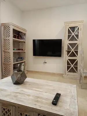 a living room with a tv and a remote control on a table at Azvalia - Ático Larga 112 - Terraza in El Puerto de Santa María