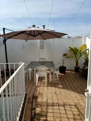 a patio with an umbrella and a table and chairs at Azvalia - Ático Larga 112 - Terraza in El Puerto de Santa María