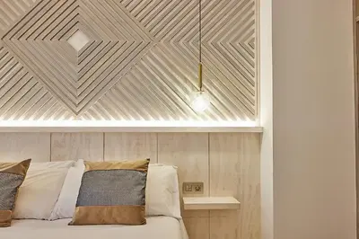 a bedroom with a wooden headboard and a bed at Little Arboli Little Apartments in Cádiz