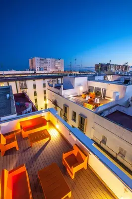 a balcony with tables and chairs on a building at Apartamentos Maier in Cádiz