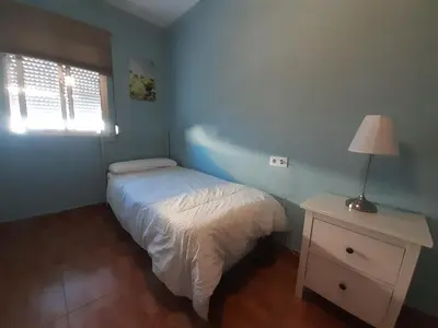 a bedroom with a bed and a lamp on a night stand at Apartamento Zona Norte in Jerez de la Frontera