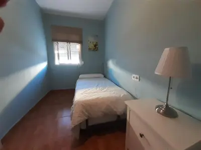 a small bedroom with a bed and a lamp at Apartamento Zona Norte in Jerez de la Frontera