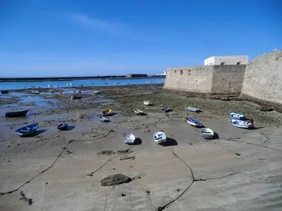 a group of boats on a beach near the water at La Nube de San Miguel in Cádiz