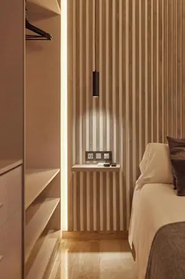 a bedroom with a bed and a shelf with a clock at Little Sopranis Little Apartments in Cádiz