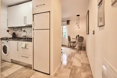 a kitchen with white cabinets and a refrigerator at Little Sopranis Little Apartments in Cádiz