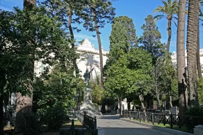 a statue in the middle of a park with trees at Little Sopranis Little Apartments in Cádiz