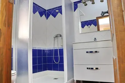 a bathroom with a shower with blue tiles at Bungalow La Roa I in Conil de la Frontera