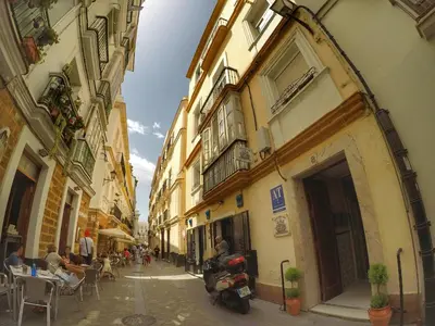 a group of people sitting at tables in an alley at Spanish Galleon Lodge in Cádiz