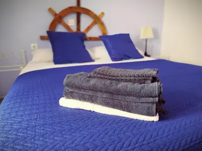 a blanket on a blue bed in a bedroom at Spanish Galleon Lodge in Cádiz