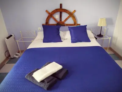 a blue bed with blue pillows and towels on it at Spanish Galleon Lodge in Cádiz