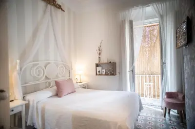 a bedroom with a white bed and a window at Palacete de La Alameda - Adults Only- in Cádiz