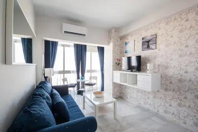 a living room with a blue couch and a tv at Apartment Altavista in Cádiz