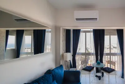 a living room with a blue couch and a mirror at Apartment Altavista in Cádiz