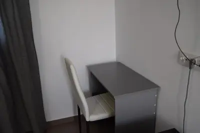a desk with a white chair next to a black desk at Alojamientos Alma in Conil de la Frontera