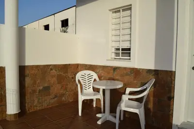 two chairs and a table in a room at Alojamientos Alma in Conil de la Frontera