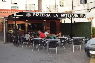 a group of people sitting at an outdoor restaurant at Alojamientos Alma in Conil de la Frontera