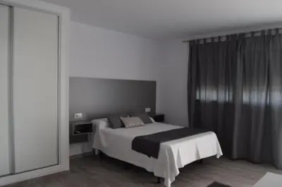 a bedroom with a bed and a large mirror at Alojamientos Alma in Conil de la Frontera