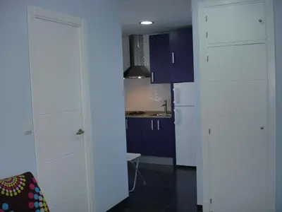 a kitchen with blue cabinets and a white refrigerator at Apartamento Cantabrico in Cádiz