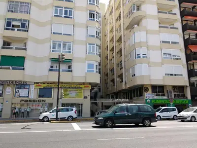 a street with cars parked in front of tall buildings at Apartamento Cantabrico in Cádiz