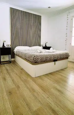 a bedroom with a large bed and a wooden floor at Sopranis by Gades Gestión in Cádiz