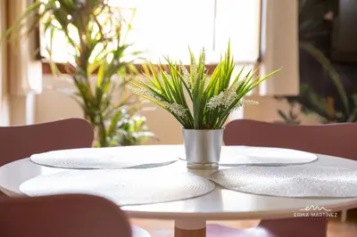 a white table with plates and a potted plant on it at Jerez Centro MRZ Rentals in Jerez de la Frontera