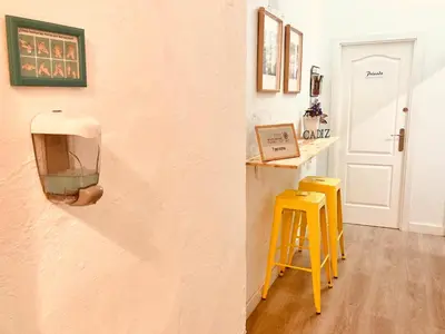 a room with two yellow stools next to a wall at Pensión Cádiz in Cádiz