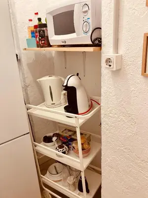 a microwave sitting on top of a shelf in a kitchen at Pensión Cádiz in Cádiz