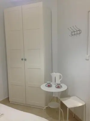 a white room with a table and a cabinet at Pensión Cádiz in Cádiz