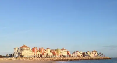 a group of houses on a beach with the ocean at Apartamento Playa Muralla in El Puerto de Santa María