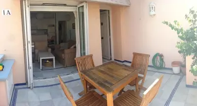 a wooden table and chairs in a living room at Apartamento Playa Muralla in El Puerto de Santa María
