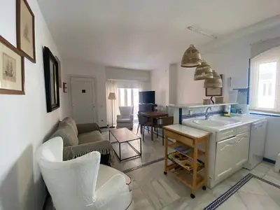 a kitchen and living room with a couch and a table at Apartamento Playa Muralla in El Puerto de Santa María