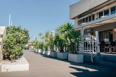 a sidewalk next to a building with a row of plants at Hotel Puerto Sherry in El Puerto de Santa María