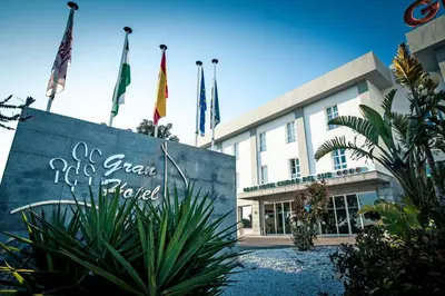 a sign in front of a building with flags at Gran Hotel Ciudad Del Sur in Puerto Real