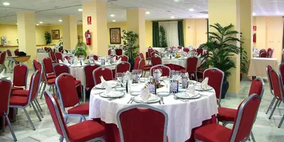 a banquet hall with tables and chairs with white table cloth at Gran Hotel Ciudad Del Sur in Puerto Real
