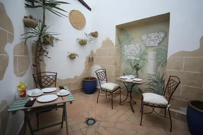 a room with two tables and chairs and plants at Hotel YIT Casa Grande in Jerez de la Frontera