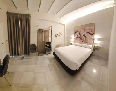 a bedroom with a large white bed in a room at Hotel YIT Casa Grande in Jerez de la Frontera