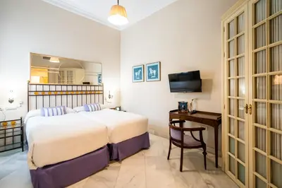 a bedroom with a bed and a desk and a television at Hotel YIT Casa Grande in Jerez de la Frontera