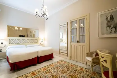 a bedroom with a bed and a table and chairs at Hotel YIT Casa Grande in Jerez de la Frontera