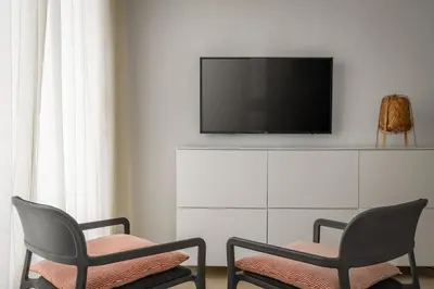 a living room with two chairs and a tv at BYPILLOW Tiento in Cádiz
