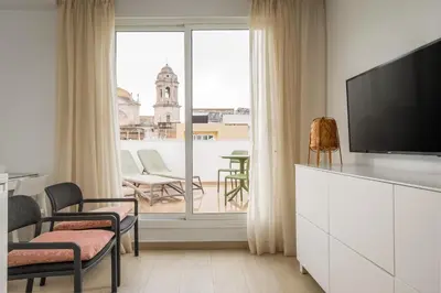 a living room with a tv and a large window at BYPILLOW Tiento in Cádiz