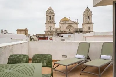 a balcony with chairs and a view of a building at BYPILLOW Tiento in Cádiz