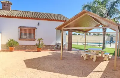 a pavilion with a picnic table and a picnic bench at Chalet Vigía 114 in Conil de la Frontera