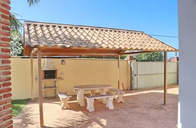 a pavilion with a picnic table and two benches at Chalet Vigía 114 in Conil de la Frontera